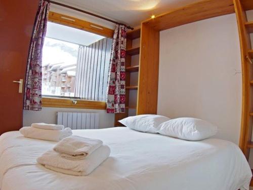 una camera da letto con un letto e due asciugamani di Appartement Valmorel, 1 pièce, 4 personnes - FR-1-291-814 a Valmorel