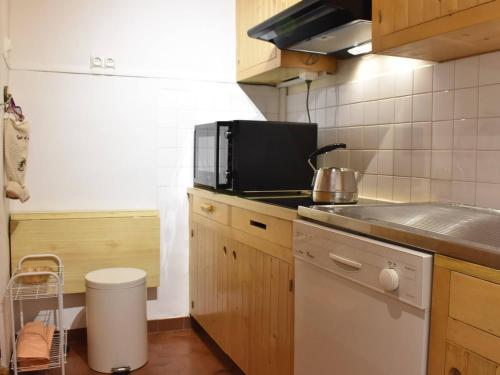 a kitchen with a microwave and a stove top oven at Appartement Méribel, 1 pièce, 5 personnes - FR-1-180-366 in Les Allues