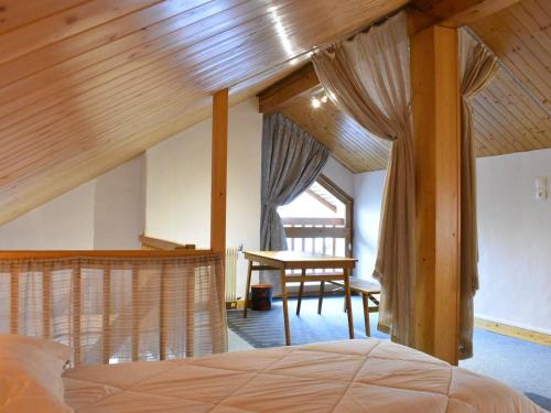 une chambre avec un lit et une table dans une pièce dans l'établissement Studio mezzanine 5 pers. à Méribel, 100m des pistes, proche commerces - Balcon, parking, casier à skis - FR-1-180-366, à Les Allues