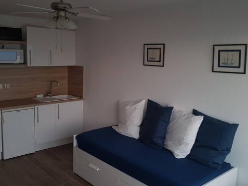 - une cuisine avec un lit doté d'oreillers bleus et blancs dans l'établissement Appartement en bord de mer avec ascenseur - Le Lavandou - FR-1-308-77, au Lavandou