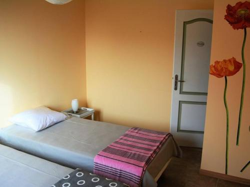 - une chambre avec un lit et une porte ornée de fleurs sur le mur dans l'établissement Villa 4* à Vallon-Pont-d'Arc avec piscine privée, jardin clôturé, climatisation et WiFi - FR-1-382-63, à Vallon-Pont-dʼArc