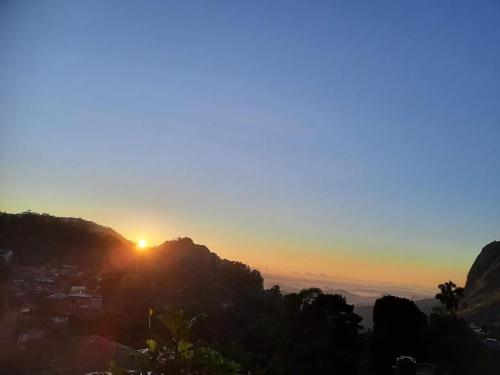 a sunset on a mountain with the sun setting at The Rock Face in Ella