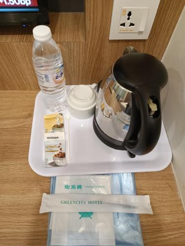 a tray with a bottle of water and a hair dryer at Greencity Hotel in Sungai Petani