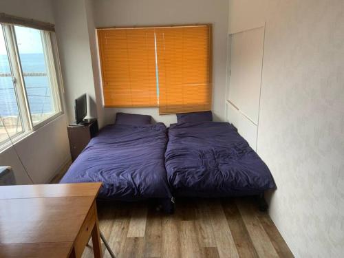 a bedroom with a bed and a desk and a window at Zenibako House 3F-RoomC in Otaru