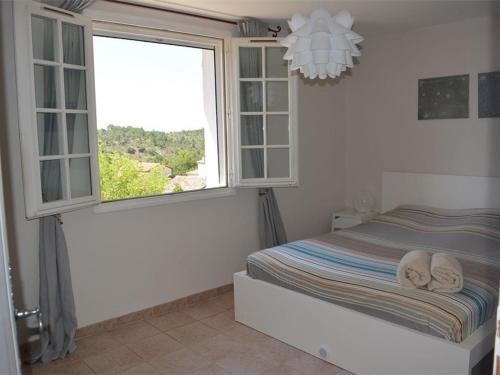 sypialnia z łóżkiem i dużym oknem w obiekcie Maison Saint-Maurice-d'Ardèche, 6 pièces, 8 personnes - FR-1-382-62 w mieście Saint-Maurice-dʼArdèche