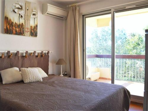 a bedroom with a bed and a large window at Appartement Le Lavandou, 2 pièces, 4 personnes - FR-1-251-200 in Le Lavandou