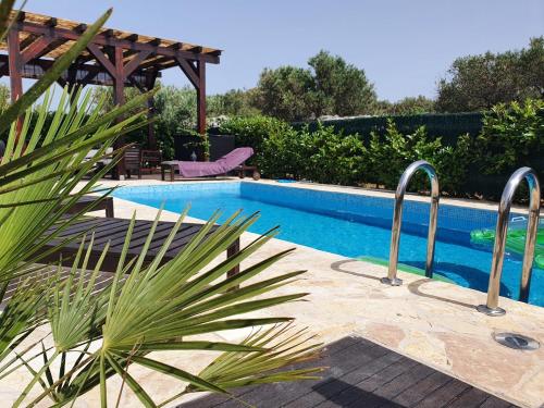 una piscina con una pérgola de madera al lado en Villa Lavandina, en Milna