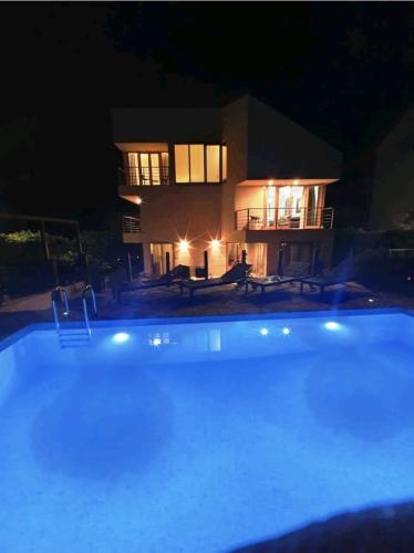 a swimming pool in front of a house at night at Villa Lavandina in Milna