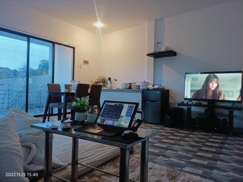 a living room with a laptop on a table and a tv at CHIEF'S VILLA Rentals Malapascua Island in Malapascua Island