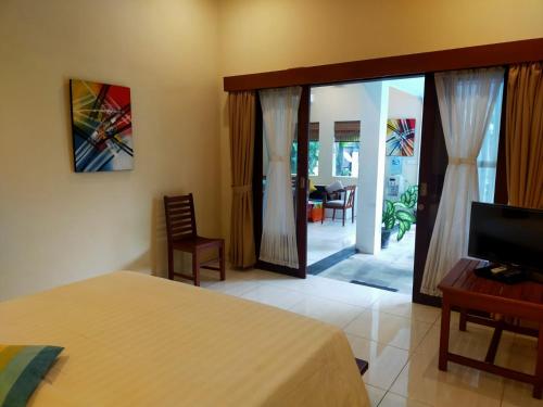 a bedroom with a bed and a sliding glass door at Lafayette House Canggu Bali in Canggu