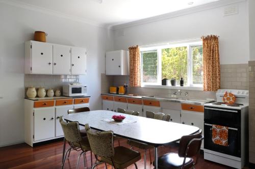 a kitchen with a table and chairs in a kitchen at Hoopers Cottage in Aldgate