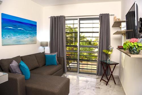 a living room with a couch and a large window at Apartamento Aquamarina, ideal trabajo/vacaciones in Cancún