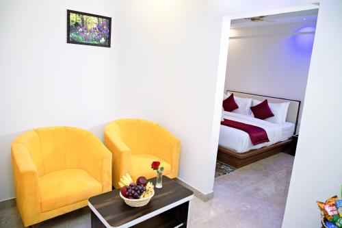 Villa Grand Hotel Near Kempegowda International Airport في بانغالور: كرسيين وطاولة في غرفة بسرير