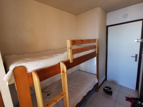 2 Etagenbetten in einem kleinen Zimmer mit einer Tür in der Unterkunft Studio Saint-Michel-de-Chaillol, 1 pièce, 4 personnes - FR-1-393-52 in Saint-Michel-de-Chaillol