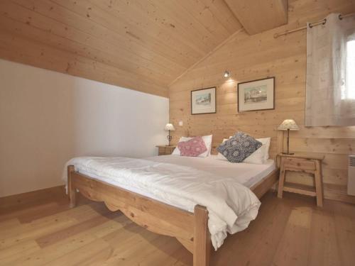a bedroom with a large bed in a wooden cabin at Appartement Le Grand-Bornand, 4 pièces, 8 personnes - FR-1-391-3 in Le Grand-Bornand