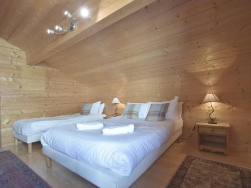 2 Betten in einem Zimmer mit Holzwänden in der Unterkunft Chalet Le Grand-Bornand, 5 pièces, 15 personnes - FR-1-391-24 in Le Grand-Bornand