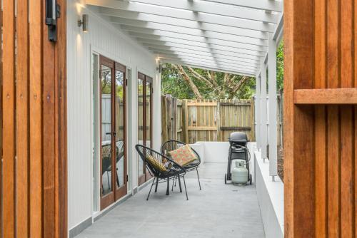 a patio with chairs and awning on a house at Espadrille Casita in Byron Bay