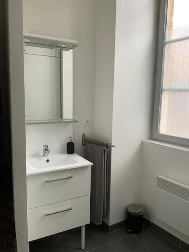 a white bathroom with a sink and a mirror at STUDIO Dole Grevy deux étoiles, in Dole