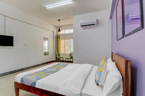 een slaapkamer met een bed en een tv aan de muur bij Capital O Elite Stay Jp Nagar Near SRI SATHYA GANAPATHI SHIRDI SAIBABA Temple in Bangalore