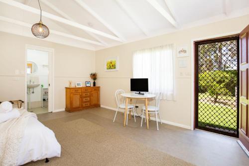 a bedroom with a bed and a table with a computer at Callala Calm Pet Friendly 5 Mins Walk to Beach in Callala Bay