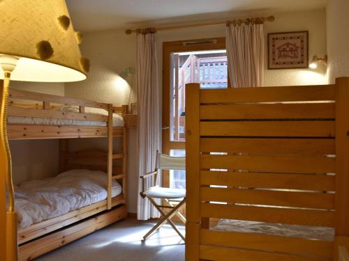a bedroom with two bunk beds and a chair at Appartement Méribel, 2 pièces, 5 personnes - FR-1-180-358 in Méribel