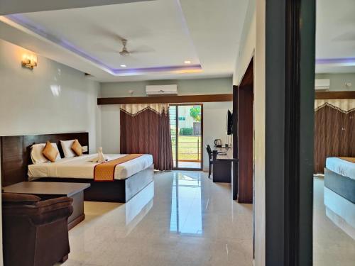 a hotel room with a bed and a living room at Bandipur Wildlife Resort & Spa, Bandipur in Bandipūr