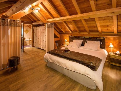 une chambre avec un grand lit dans une pièce avec des plafonds en bois dans l'établissement Chalet 6 pers avec SPA, terrasse plein sud à Saint-Michel-de-Chaillol - FR-1-393-22, à Saint-Michel-de-Chaillol