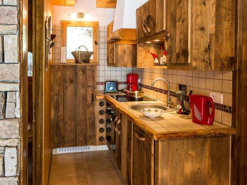 Elle comprend une petite cuisine avec des placards en bois et un évier. dans l'établissement Chalet 6 pers avec SPA, terrasse plein sud à Saint-Michel-de-Chaillol - FR-1-393-22, à Saint-Michel-de-Chaillol