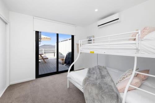 a bedroom with a bunk bed and a balcony at Park View Townhouse With Rooftop Terrace in Torquay