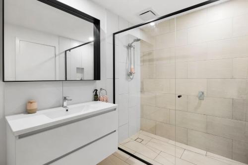a white bathroom with a sink and a shower at Park View Townhouse With Rooftop Terrace in Torquay