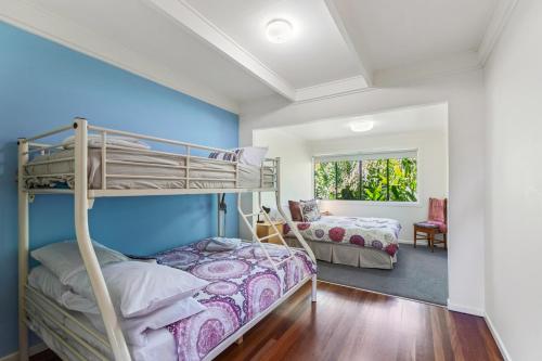 a bedroom with two bunk beds and a window at Farrants Hill - Tweed Coast Holidays in Clothiers Creek