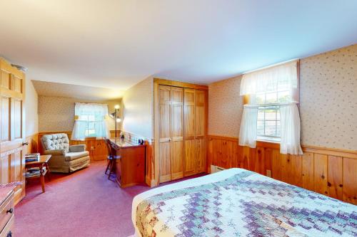 1 dormitorio con cama, escritorio y silla en Montgomery Cottage, en Rockland