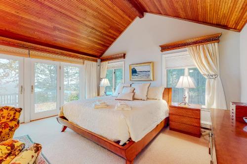 ein Schlafzimmer mit einem großen Bett und einer Holzdecke in der Unterkunft Penobscot Bay House in Camden