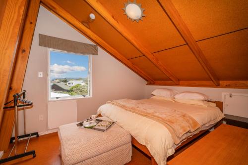 パウアヌイにあるPauanui Beach Therapy - Pauanui Holiday Homeのベッドルーム(ベッド1台、窓付)