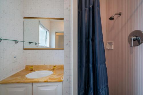 a bathroom with a sink and a mirror at Pauanui Beach Therapy - Pauanui Holiday Home in Pauanui