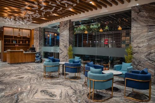 a lobby of a hotel with blue chairs and tables at Lords Inn Rajkot in Rajkot