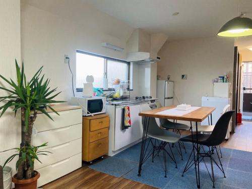 a kitchen with a table and a kitchen with a table and chairs at スペース東京Hostel in Tokyo