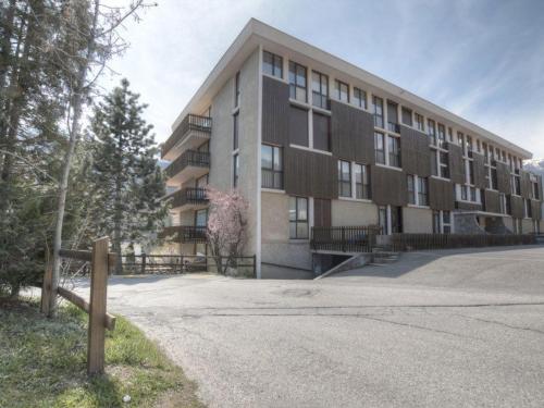 un grand bâtiment avec une route devant lui dans l'établissement Charmant studio tout équipé pour 2 pers, Serre-Chevalier, parking et casier à ski inclus - FR-1-330E-66, à Saint-Chaffrey