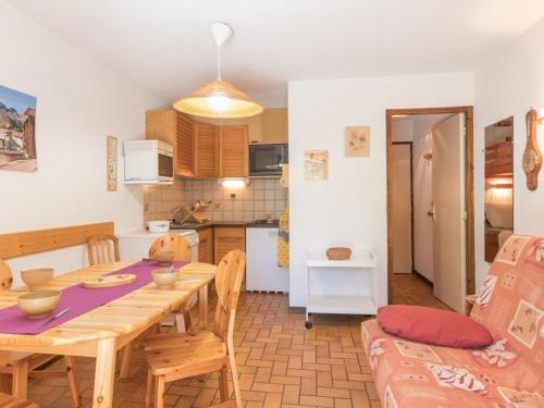 une cuisine et une salle à manger avec une table et des chaises en bois dans l'établissement Monêtier Les Bains - Appartement 3 pièces avec jardin, rénové, proche Grands Bains - FR-1-330F-75, au Monêtier-les-Bains
