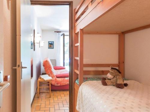 misia siedzącego na łóżku w sypialni w obiekcie Appartement Le Monêtier-les-Bains, 2 pièces, 5 personnes - FR-1-330F-75 w mieście Le Monêtier-les-Bains
