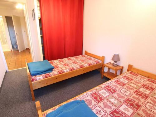 セレ・シュヴァリエにあるAppartement La Salle-les-Alpes, 3 pièces, 8 personnes - FR-1-330F-71のベッド2台と赤いカーテンが備わる客室です。