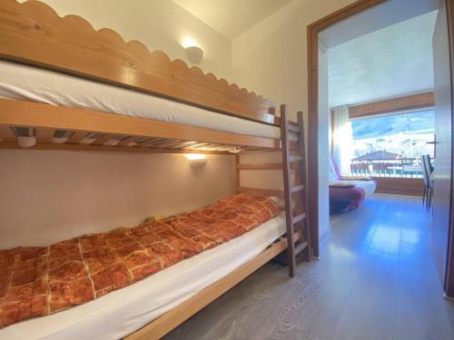 a bedroom with two bunk beds and a balcony at Appartement Praz-sur-Arly, 1 pièce, 4 personnes - FR-1-603-11 in Praz-sur-Arly