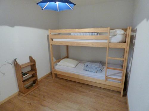 Cette chambre dispose de lits superposés avec deux lits superposés et une lampe. dans l'établissement Appartement montagnard 6-7 pers, proche télécabines, RDC, parking fermé - FR-1-458-91, au Grand-Bornand