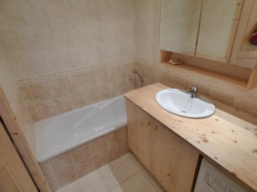 une salle de bain avec un lavabo et une baignoire dans l'établissement Appartement montagnard 6-7 pers, proche télécabines, RDC, parking fermé - FR-1-458-91, au Grand-Bornand
