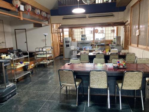 une grande salle à manger avec une table et des chaises dans l'établissement 民宿ニュー万福茶屋, à Taketa