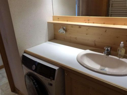 une salle de bain avec un lavabo et une machine à laver dans l'établissement Appartement moderne avec balcon et garage, au pied des pistes au Chinaillon pour 4 personnes - FR-1-458-161, au Grand-Bornand