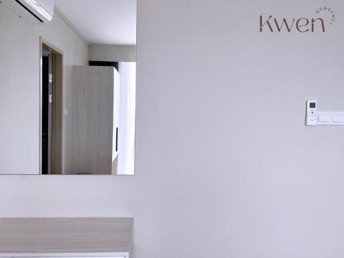 a room with a mirror and a kitchen with a refrigerator at KWEN Suites-Tanjung Aru InfinityPool Seaview/Airport View in Kota Kinabalu
