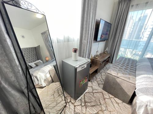 a bedroom with a mirror and a bed and a television at Luxury Room with Marina view close to JBR Beach and Metro with Shared Kitchen in Dubai