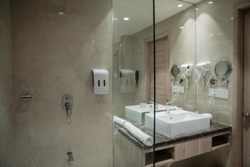 a bathroom with a sink and a glass shower at Lords Inn Rajkot in Rajkot