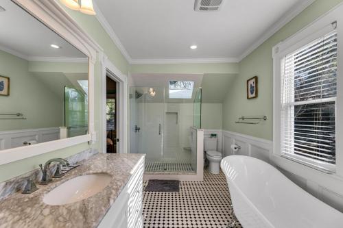 La salle de bains est pourvue d'une baignoire, d'un lavabo et d'une douche. dans l'établissement The Magnolia Manor - Private Backyard - Close to Downtown, à Greensboro
